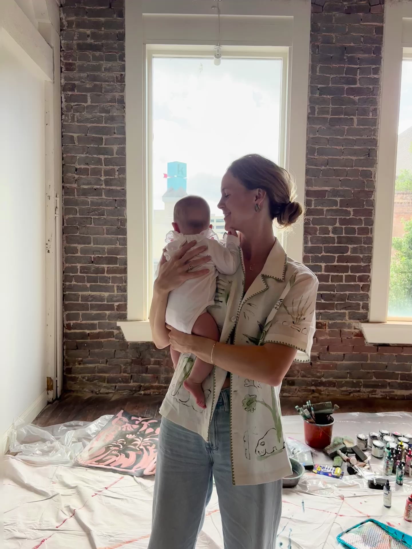 Video of Artist Mary Ball kissing her baby on the cheek while wearing the 'Seasons of Change' Shirt in Green. 