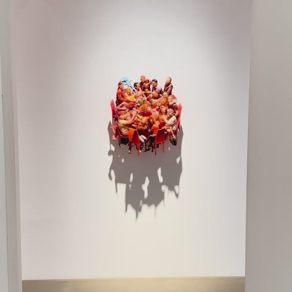A video showing the details of a relief sculpture in a gallery. The sculpture shows an animated Chinese family dinner.