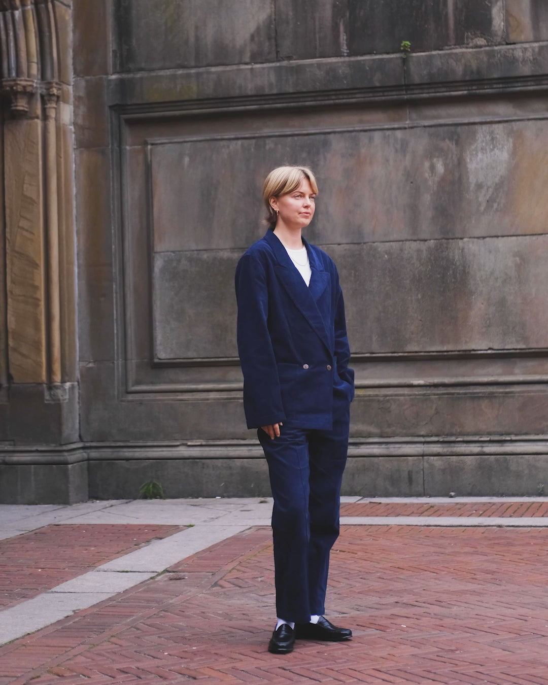 Video of woman wearing full navy corduroy suit. 