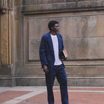 Video of man in full navy corduroy Easy Going Suit, carrying a few books.