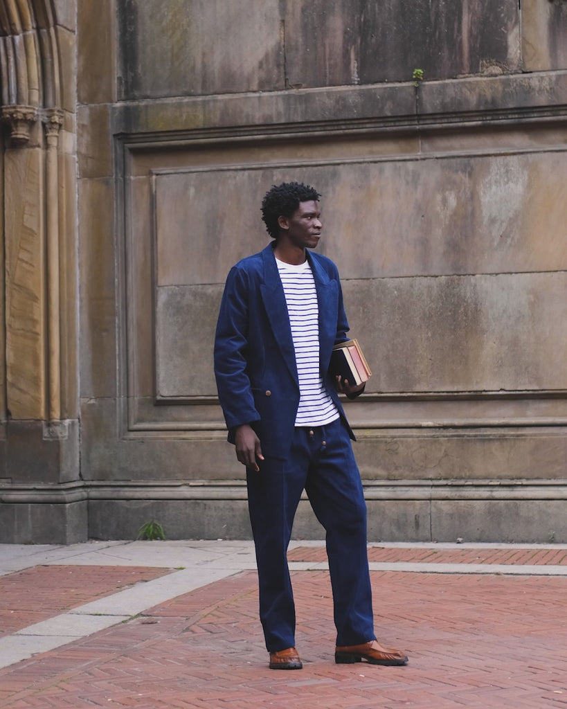 Video of man in full navy corduroy Easy Going Suit, carrying a few books.