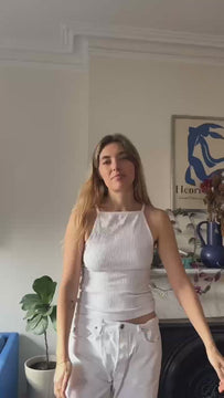 Aemelia talks to the camera, snaps fingers, and then reappears with the conched out shirt on, proceeding to explain how she likes to style the shirt with a denim skirt or baggy white jeans