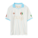 A vintage-style soccer jersey by Una and Tombolo, featuring an off-white body with light blue trim on the collar and sleeves, vertical light blue pinstripes, and gold embroidered details including 'Una' embroidery and a pizza graphic with an Italian flag.