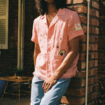 man leans against brick wall