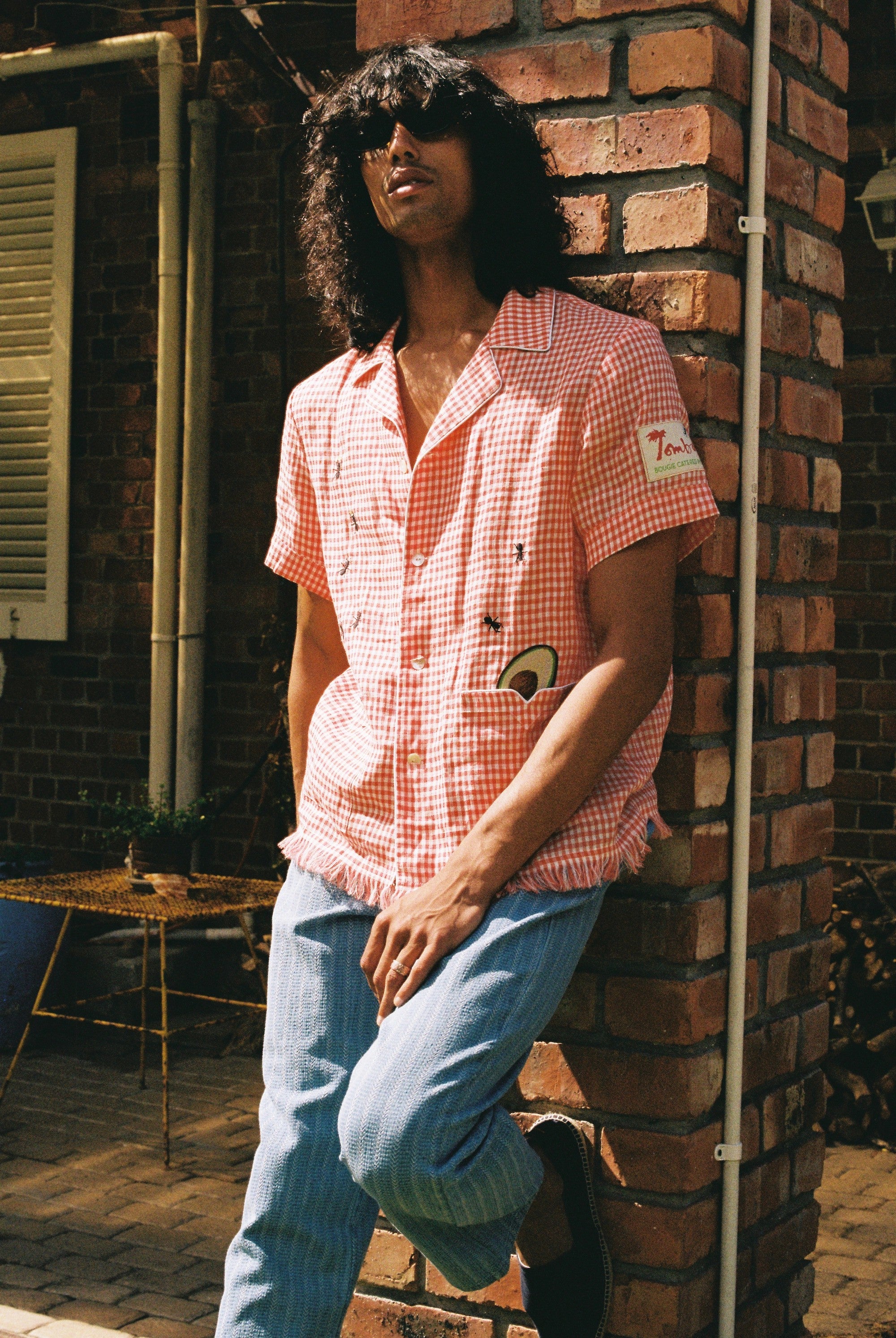 man leans against brick wall