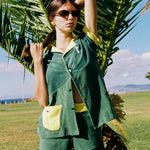 Female model posing in full set in front of a palm tree