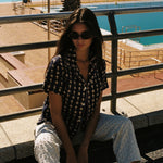 Female model posing in shirt near a pool