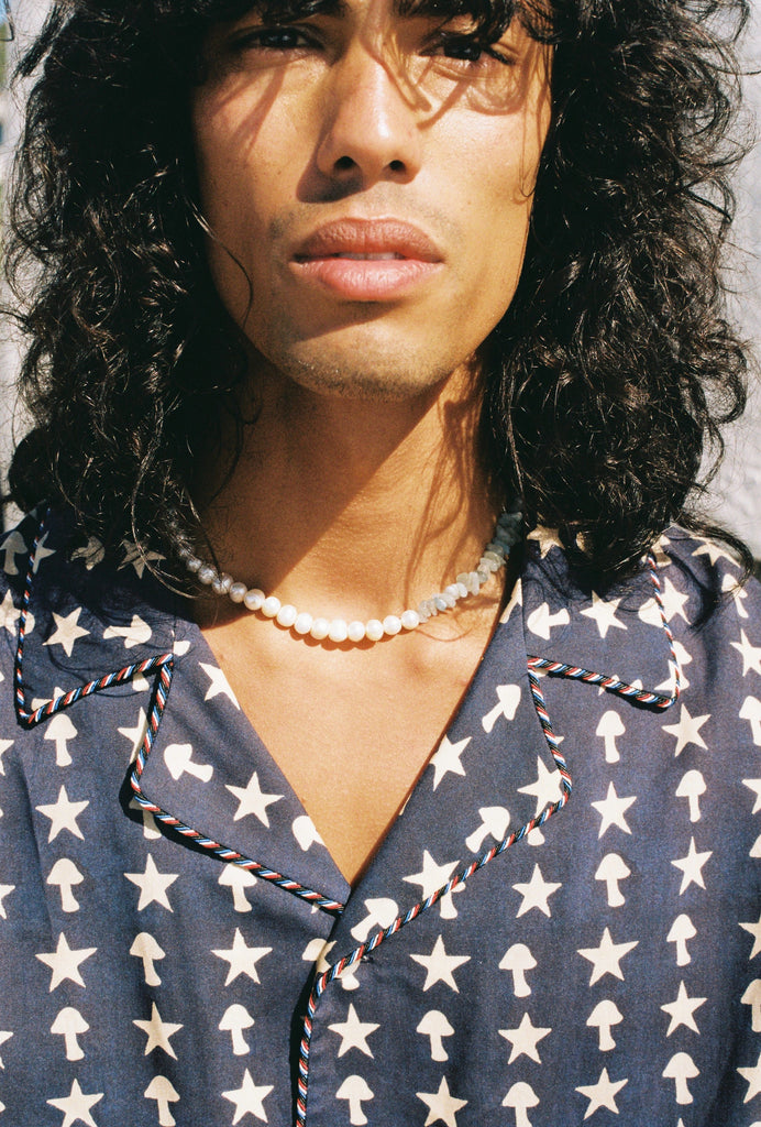 Close up of male model wearing shirt with a beaded necklace