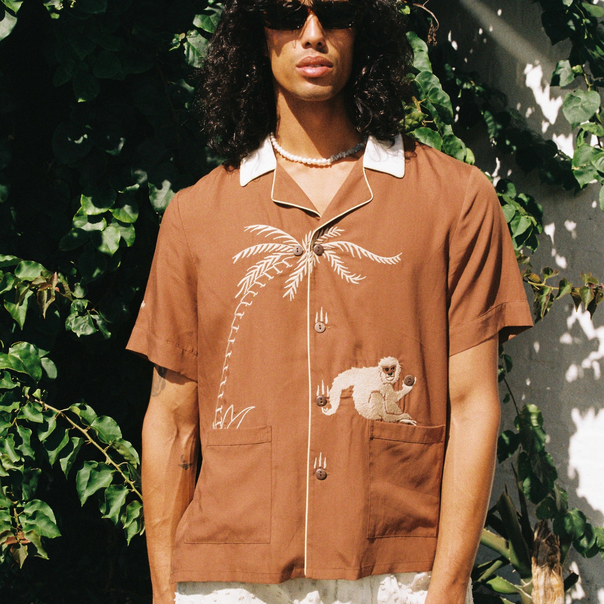 male model looking fun and fresh with our lightweight Tencel Cabana shirts, monkey, palm tree and all