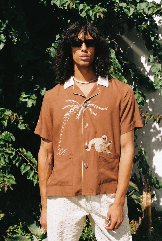 male model looking fun and fresh with our lightweight Tencel Cabana shirts, monkey, palm tree and all