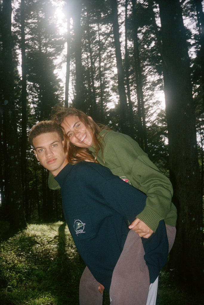 Man in navy sweater carries woman on his back