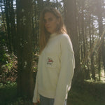 Wman stands side on while gazing at camera