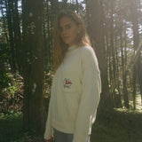 Wman stands side on while gazing at camera