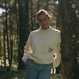 Woman leans against tree and gazes at camera