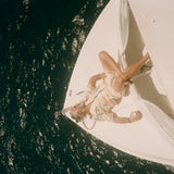 Older male model wearing full set laying out on a boat