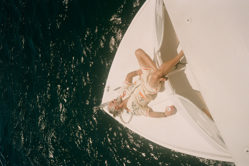 Older male model wearing full set laying out on a boat