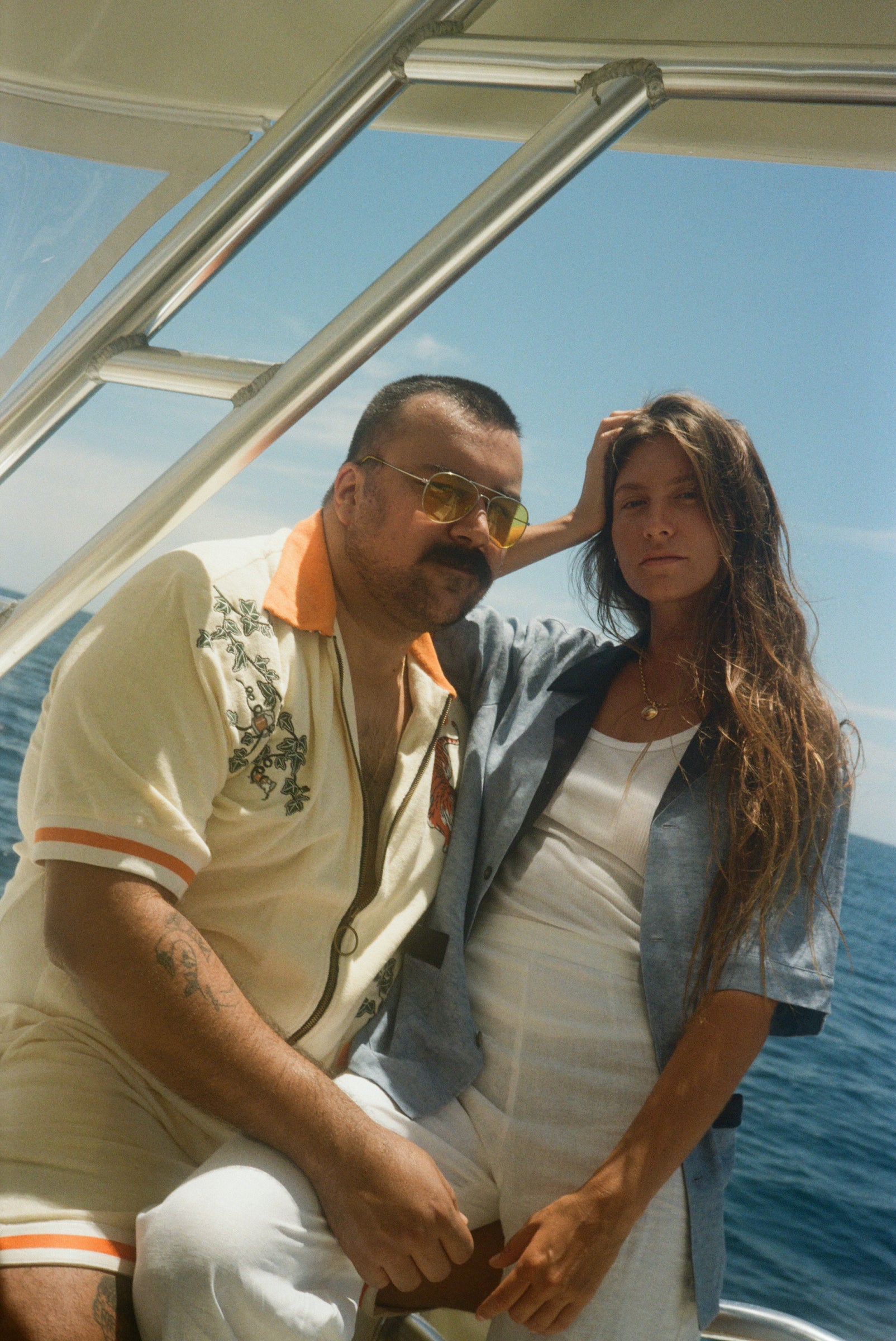 Male model wearing the tiger set leaning on a female model wearing the blue black tie optional cabana