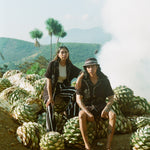 man and woman sit wearing agua magica cabanas