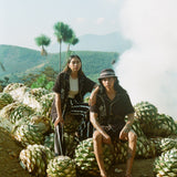 man and woman sit wearing agua magica cabanas