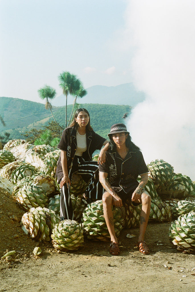man and woman sit wearing agua magica cabanas