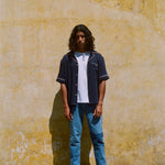 Male model wearing navy cabrisa unbuttoned standing on a wall