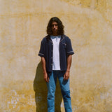 Male model wearing navy cabrisa unbuttoned standing on a wall