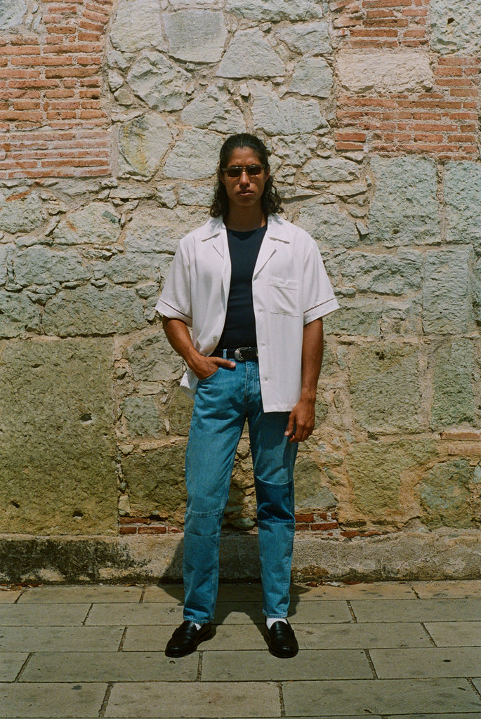 Male model wearing shirt with hand in left jean pocket