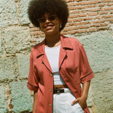 Female model wearing shirt with hand in pocket