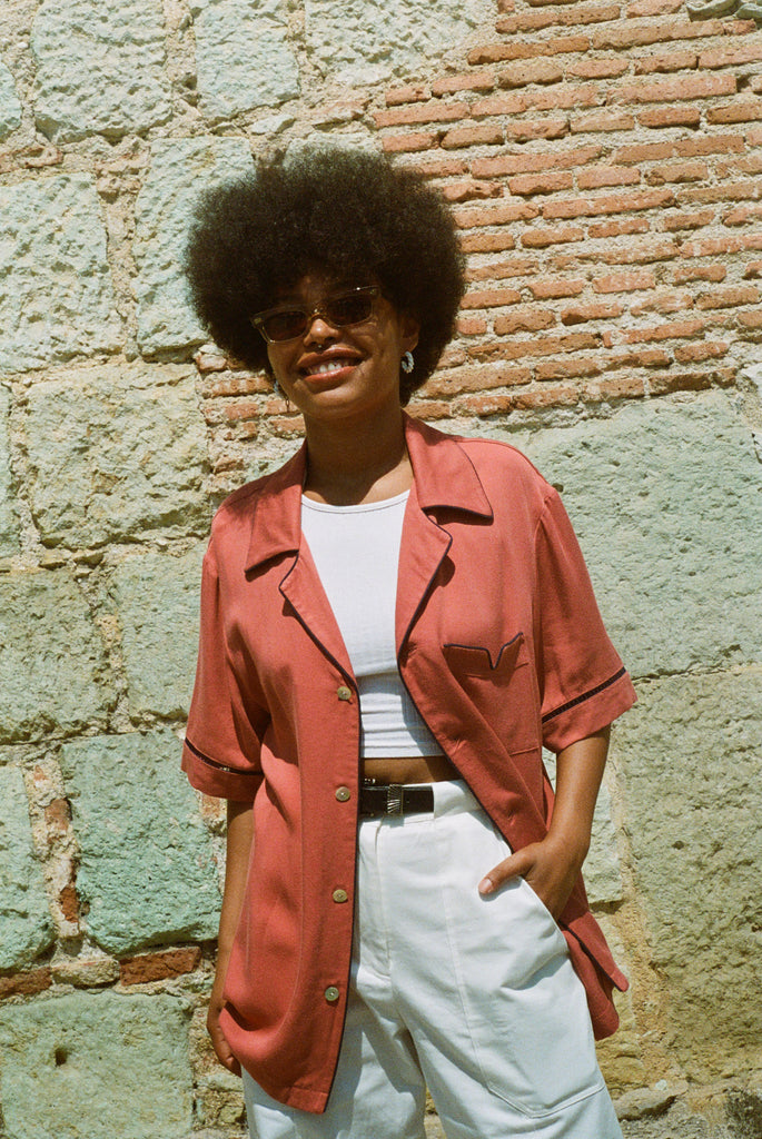 Female model wearing shirt with hand in pocket