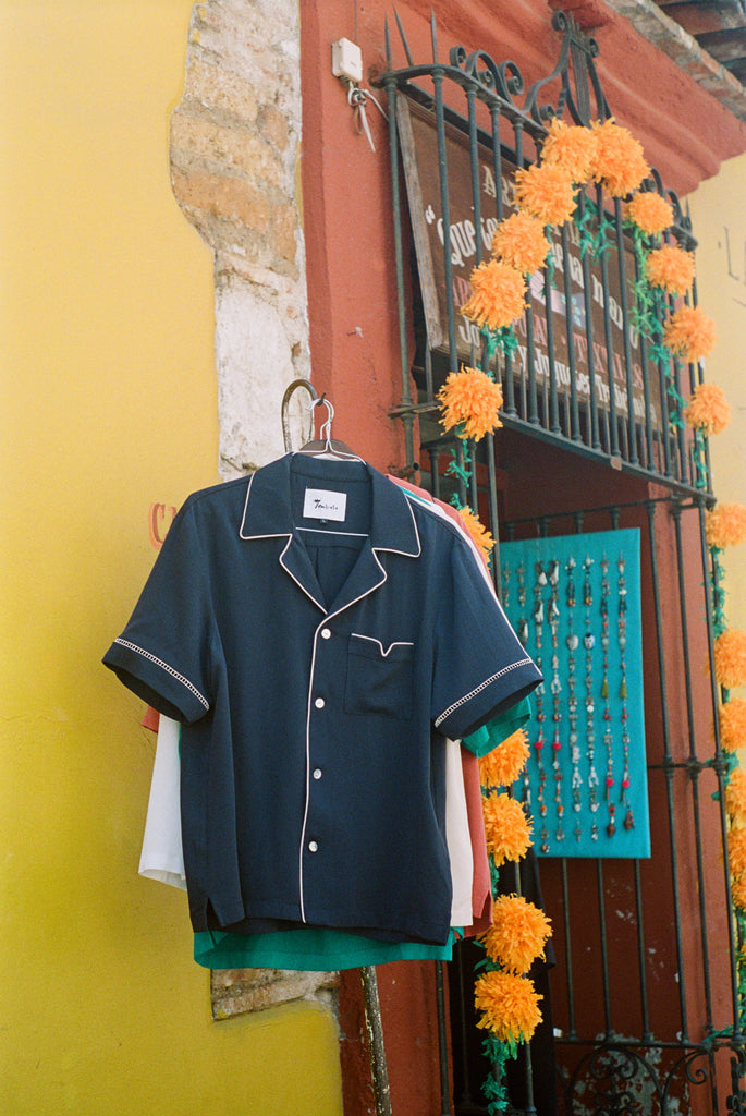 Shirt hanging up on a wall next to a store