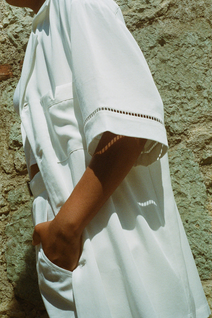 Female model wearing shirt right view with hand in pocket