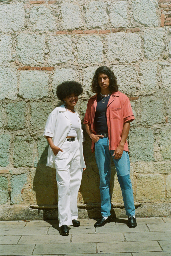 Female model in all-white outfit next to male model wearing a valencia cabrisa shirt