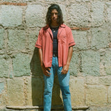 Male model wearing shirt open over a black tank and jeans