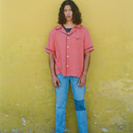 Male model in shirt with jeans on a yellow wall