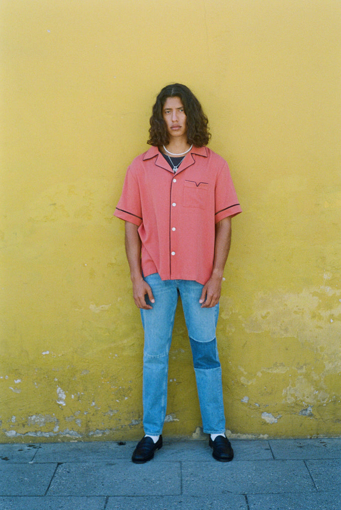 Male model in shirt with jeans on a yellow wall