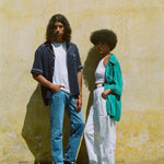 Man in navy cabrisa next to woman in teal cabrisa