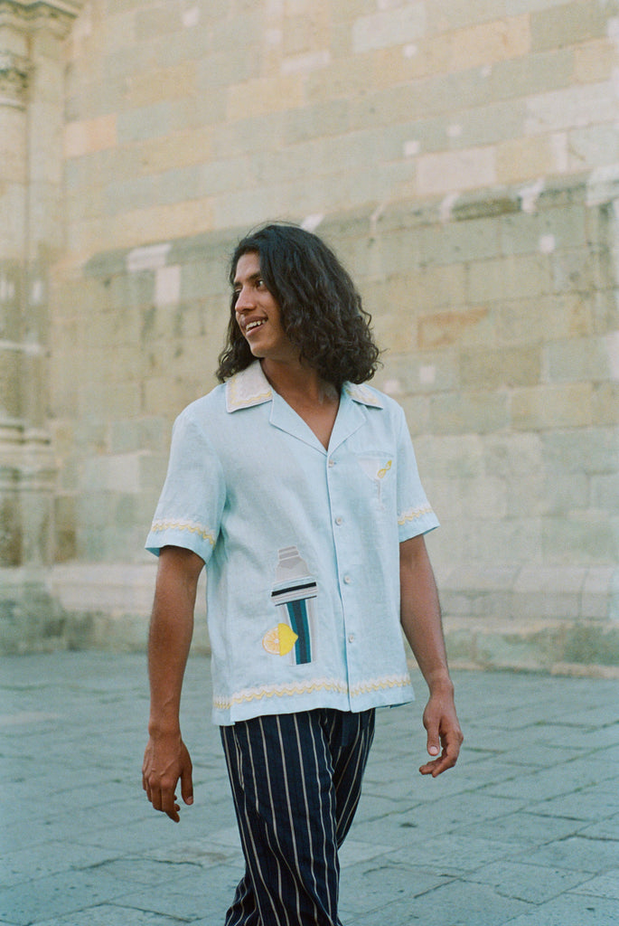 Man casually walking in Tombolo linen shirt displaying loose fit and carefree style.