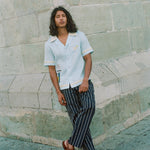 Man leaning casually against wall wearing relaxed linen Tombolo Martini shirt