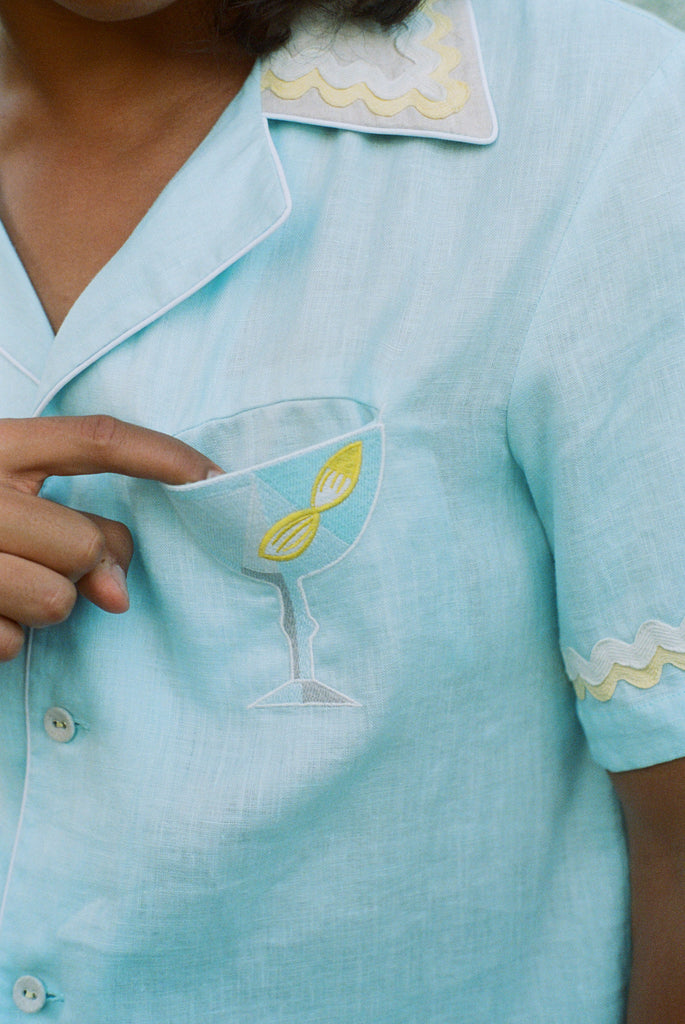 Man dropping finger inside martini glass pocket