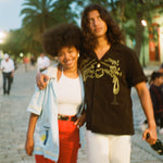 Man puts arm around woman walking through a town square while wearing Big Brut cabana shirt
