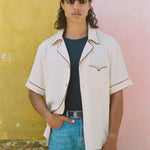 Male model wearing shirt open with hand in his jeans pocket
