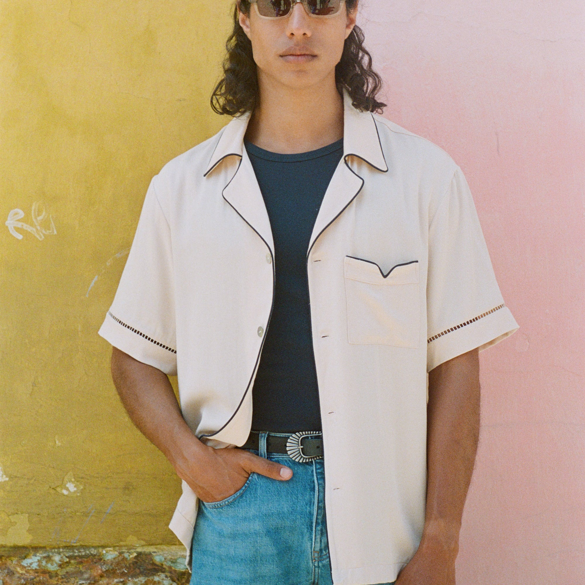 Male model wearing shirt open with hand in his jeans pocket