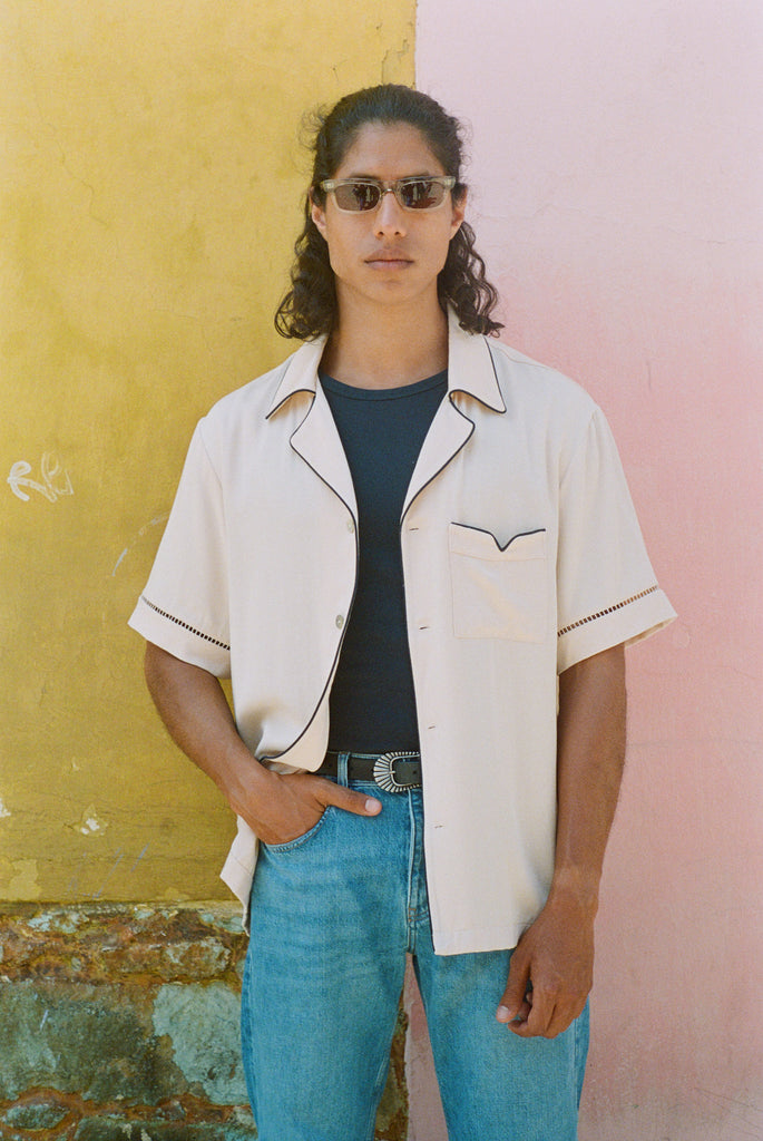 Male model wearing shirt open with hand in his jeans pocket