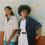 male model wearing the cabrisa shirt in parchment next to a female model wearing the cabrisa shirt in navy