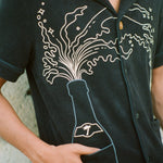 Man puts finger inside bottom shirt pocket 