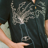 Man puts finger inside bottom shirt pocket 