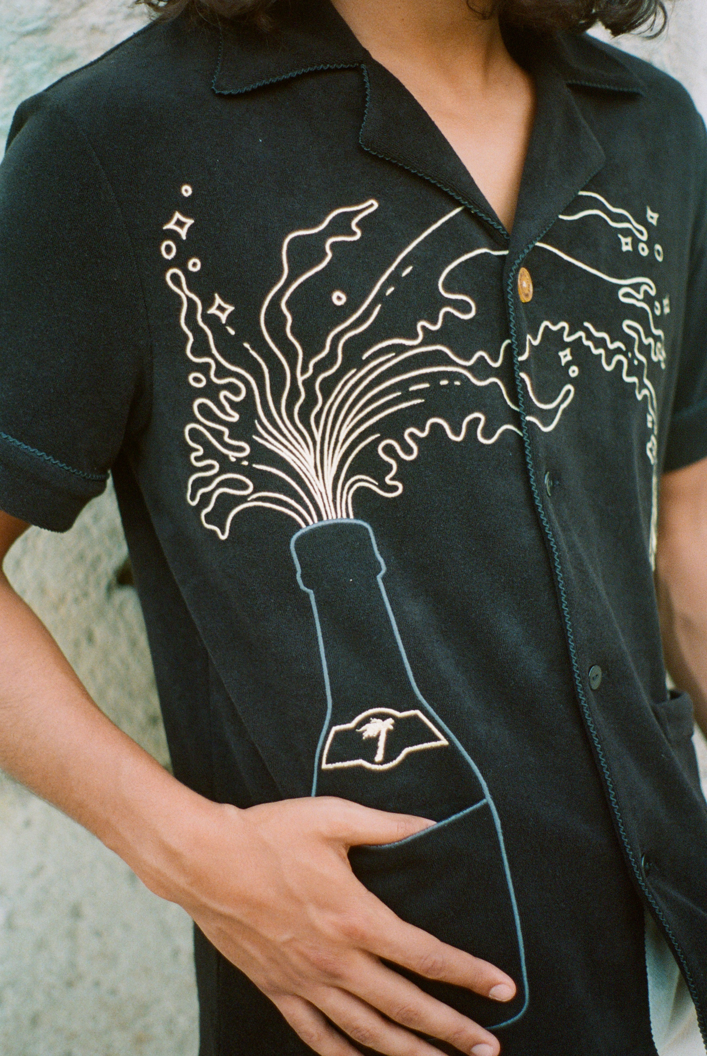 Man puts finger inside bottom shirt pocket 