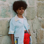 Woman leaning against wall posing in Tombolo linen shirt