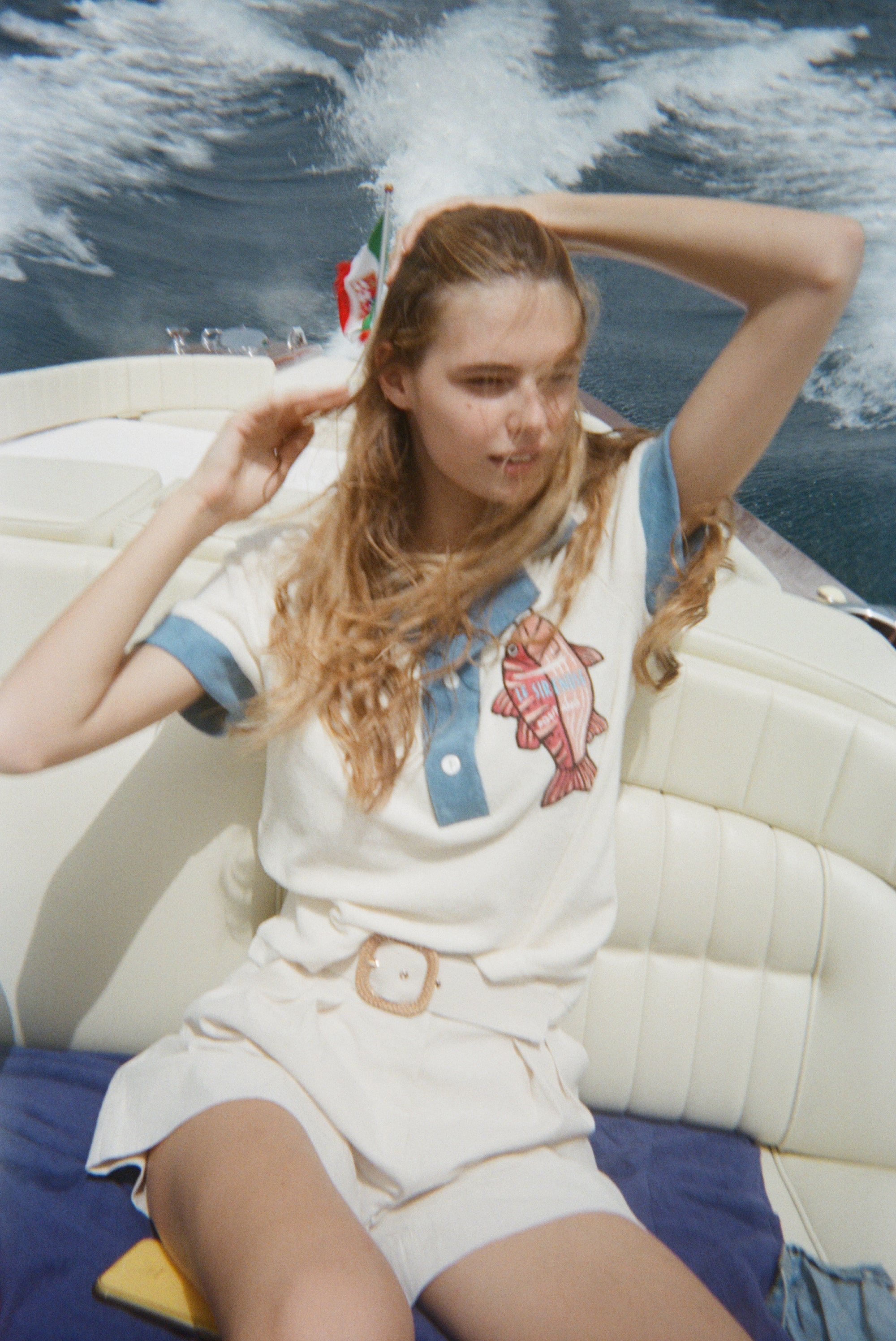 Female model in pop over on boat with white shorts