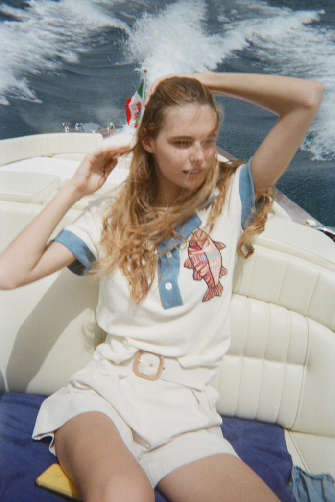 Female model in pop over on boat with white shorts